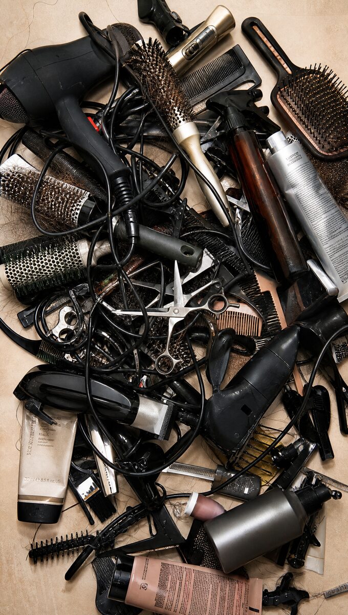 A chaotic pile of tangled hair tools, brushes and cords